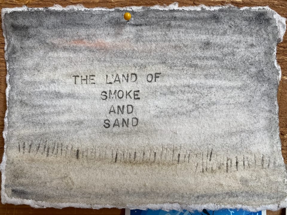 A watercolor by Laurel Hunter that has the words "The Land of Smoke and Sand"